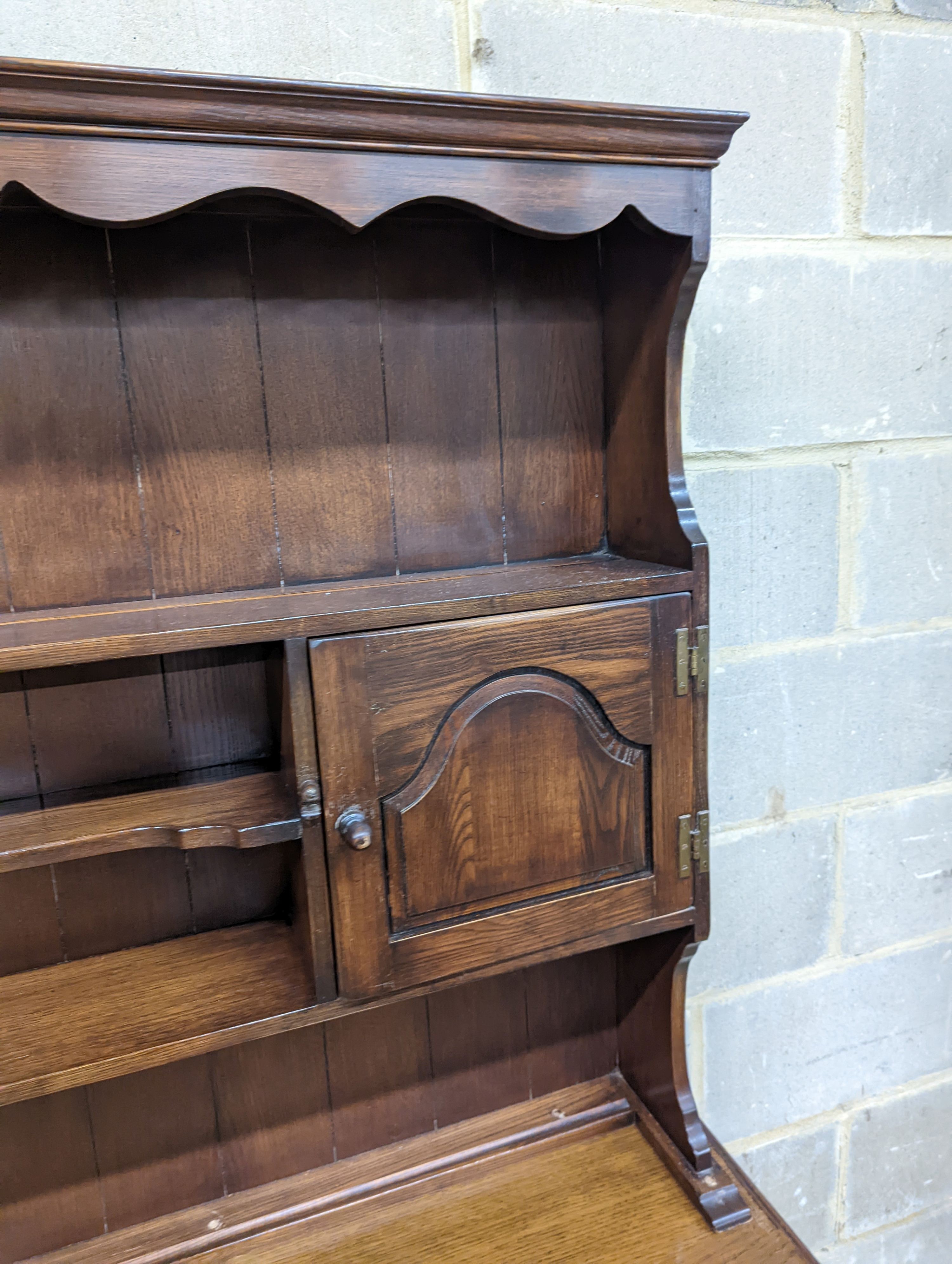 A Georgian style oak dresser base with boarded rack, W-184cm, D-46cm, H-188cm.